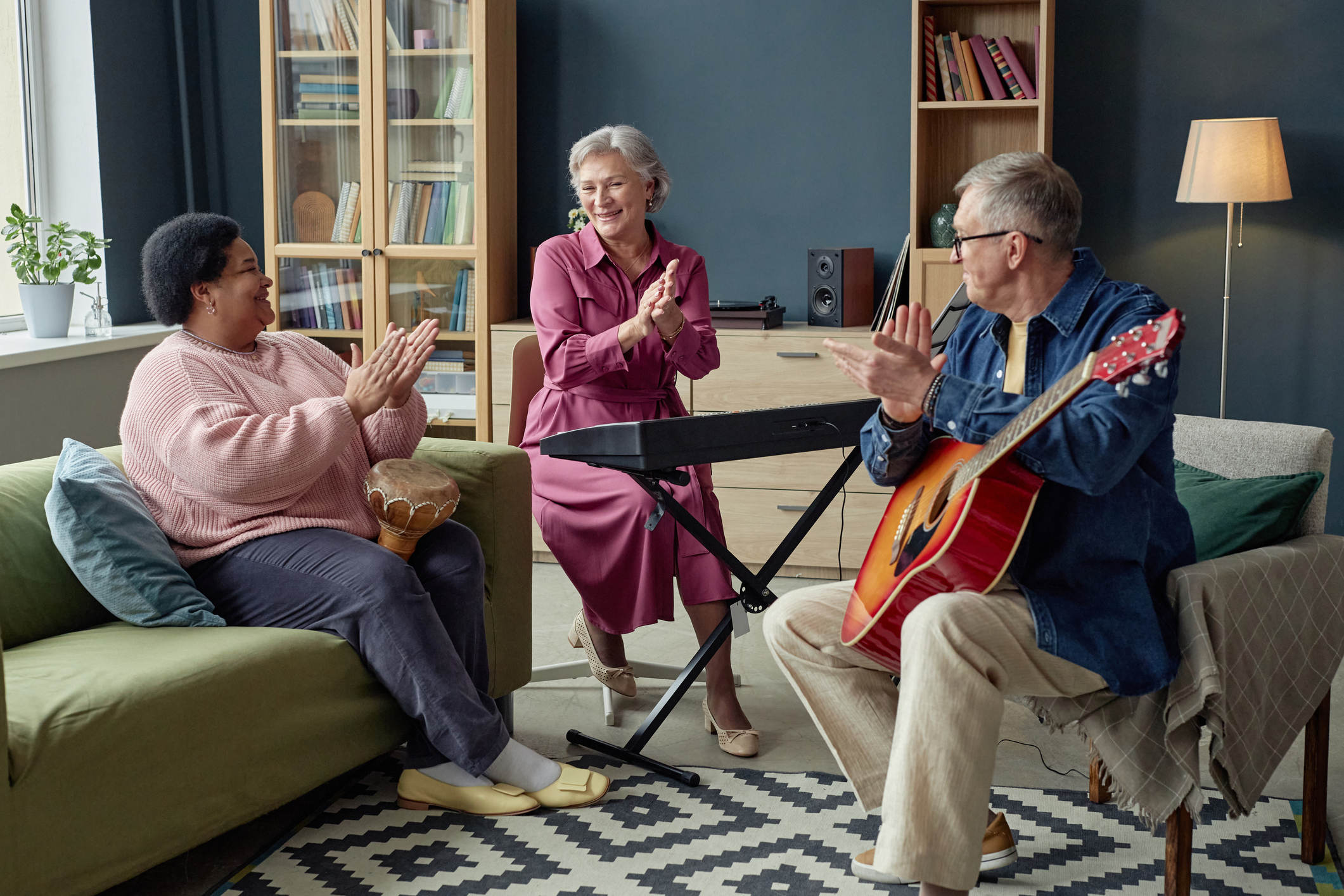 Group of creative senior people playing music together and applauding each other enjoying creative hobby in retirement home copy space