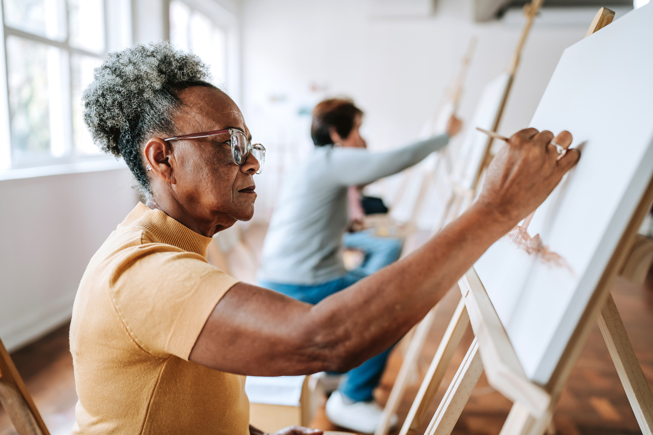 Group of seniors painting pictures in the painting studio