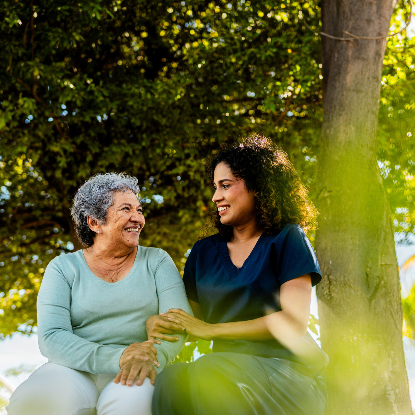Home caregiver and senior woman talking outdoors
